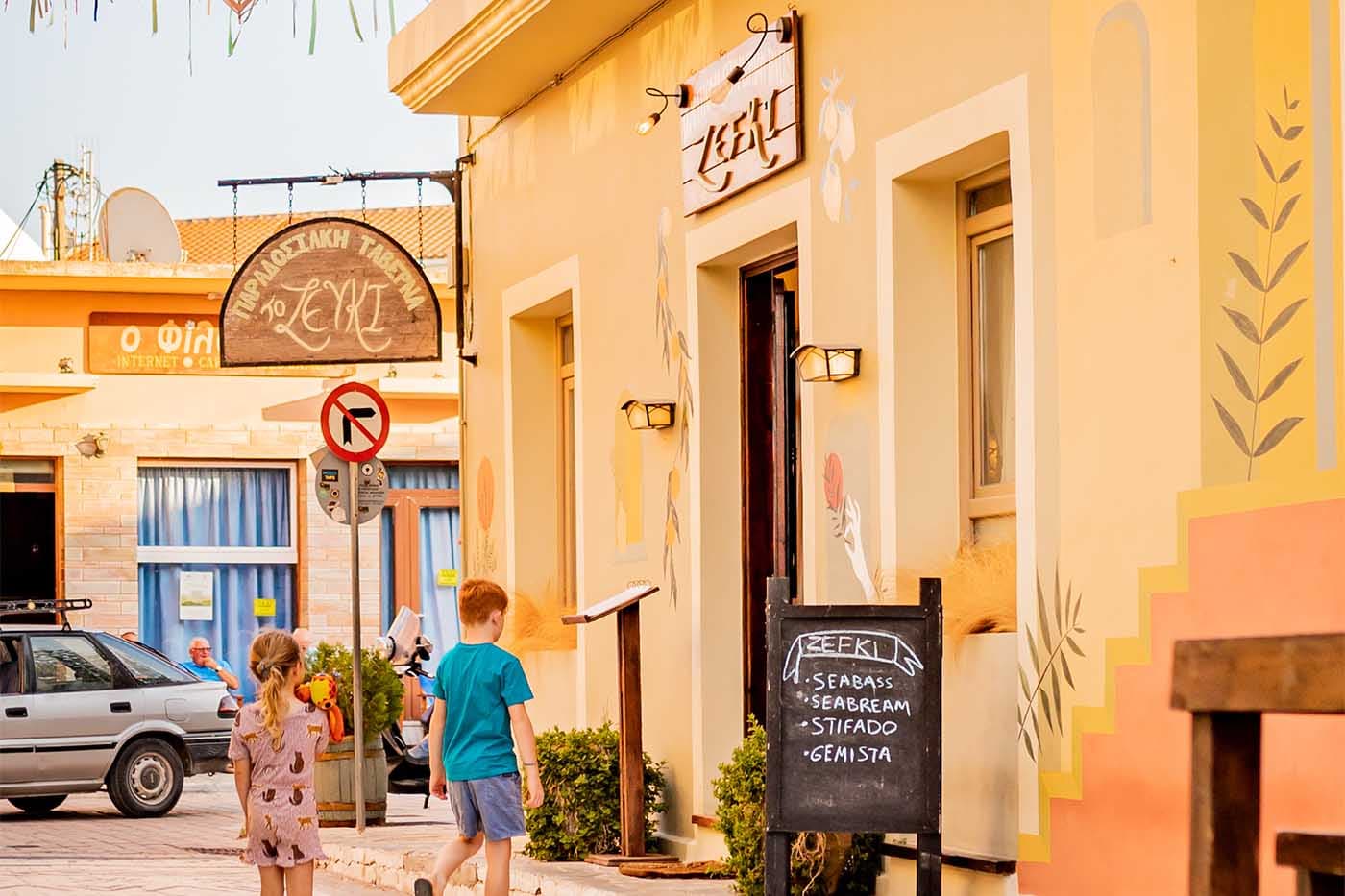 Colorful yellow buildings with traditional signage in a quiet Greek village street, Kefalonia