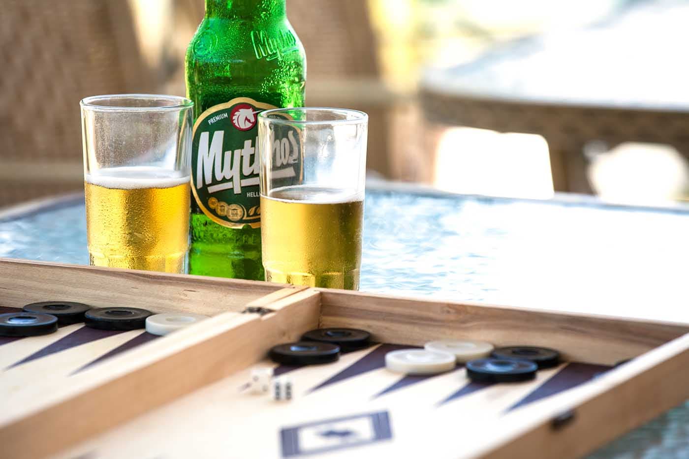 Mythos beer and Greek tavli on a harbour table